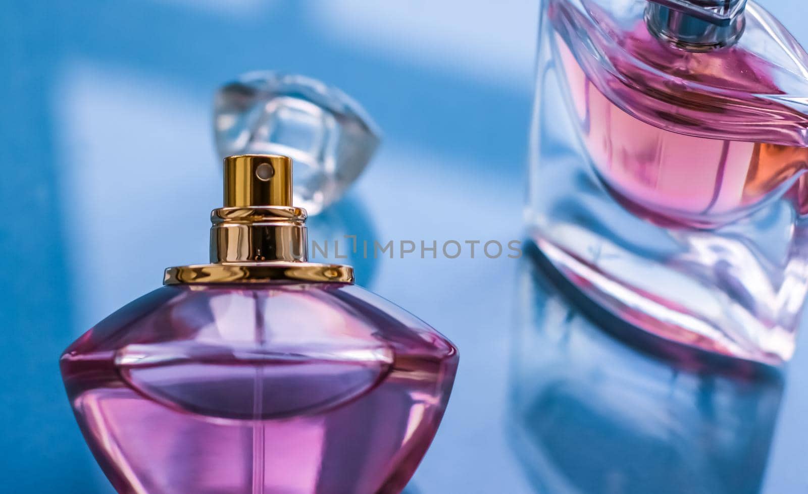 Perfumery, spa and branding concept - Pink perfume bottle on glossy background, sweet floral scent, glamour fragrance and eau de parfum as holiday gift and luxury beauty cosmetics brand design