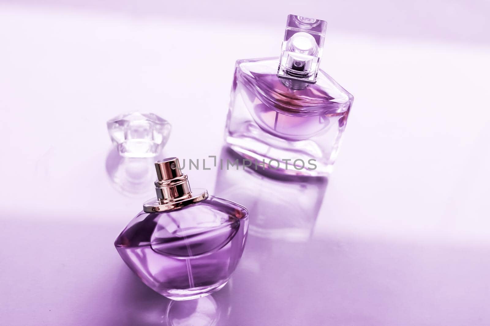 Perfumery, spa and branding concept - Purple perfume bottle on glossy background, sweet floral scent, glamour fragrance and eau de parfum as holiday gift and luxury beauty cosmetics brand design