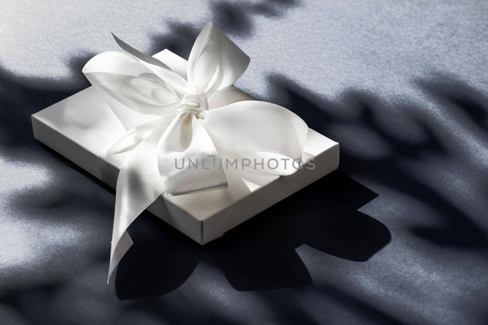 Anniversary celebration, shop sale promotion and luxe surprise concept - Luxury holiday white gift box with silk ribbon and bow on black background, luxe wedding or birthday present