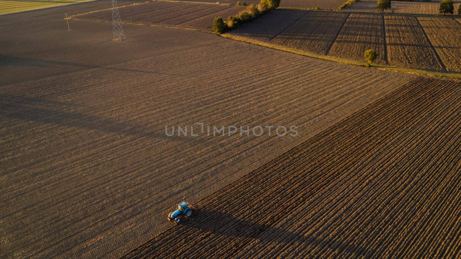 farmer with tractor leveling land in the countryside.