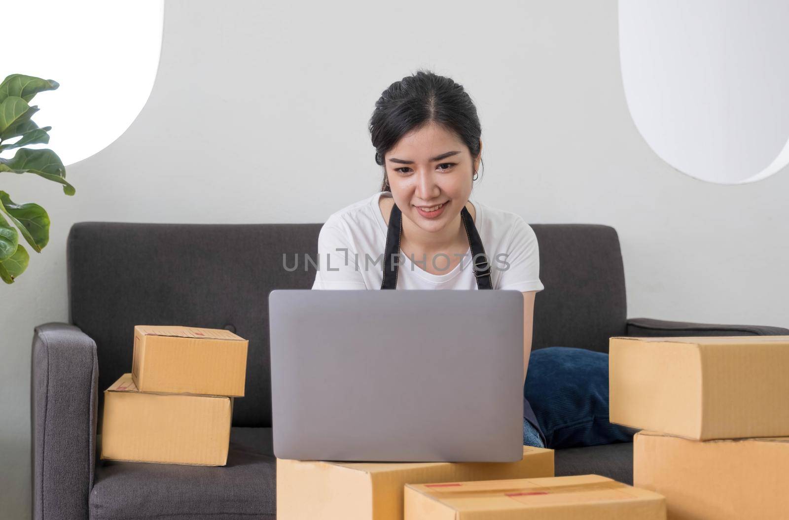 Starting Small business entrepreneur freelance,Portrait young woman working at home office, BOX,smartphone,laptop, online, marketing, packaging, delivery, SME, e-commerce concept.