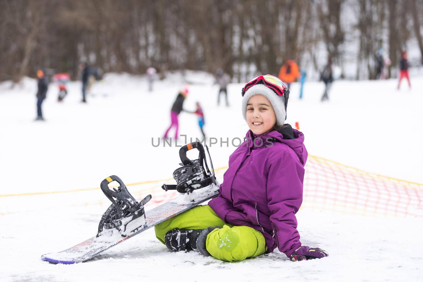 Snowboard winter sport. Cute girl with snowboard going to slide in winter nature.