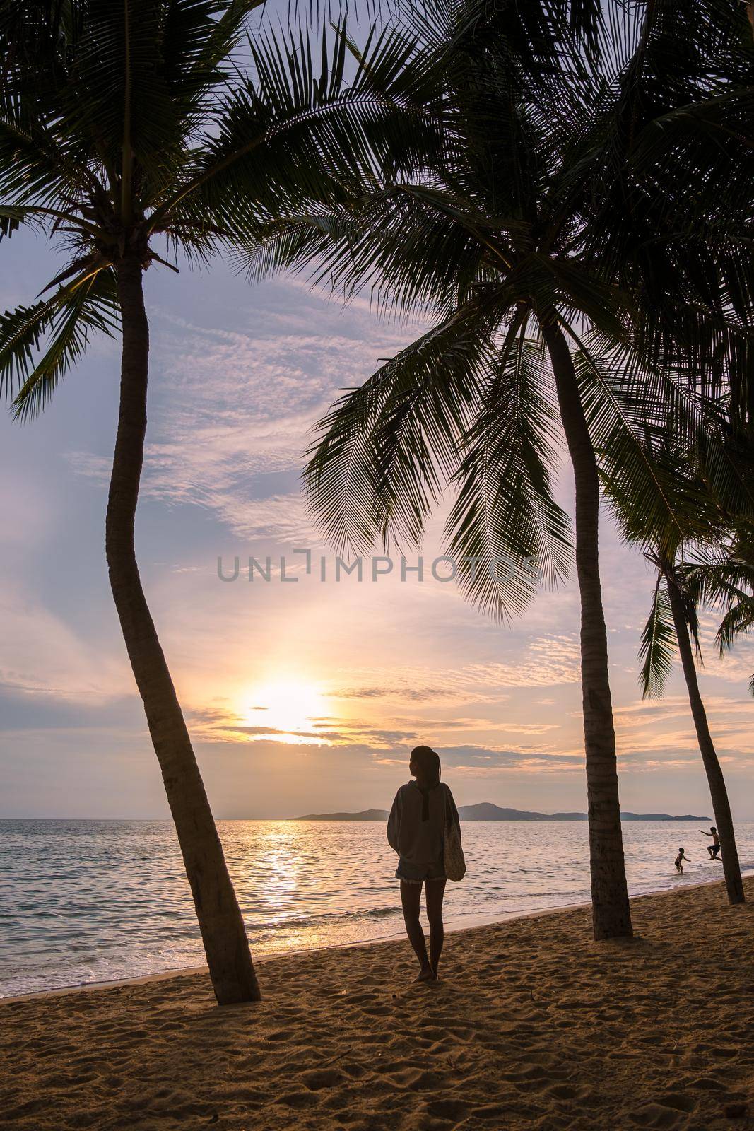 Dong Tan Beach Jomtien Pattaya Thailand during afternoon sunset. women silhouette and palm trees during sunset