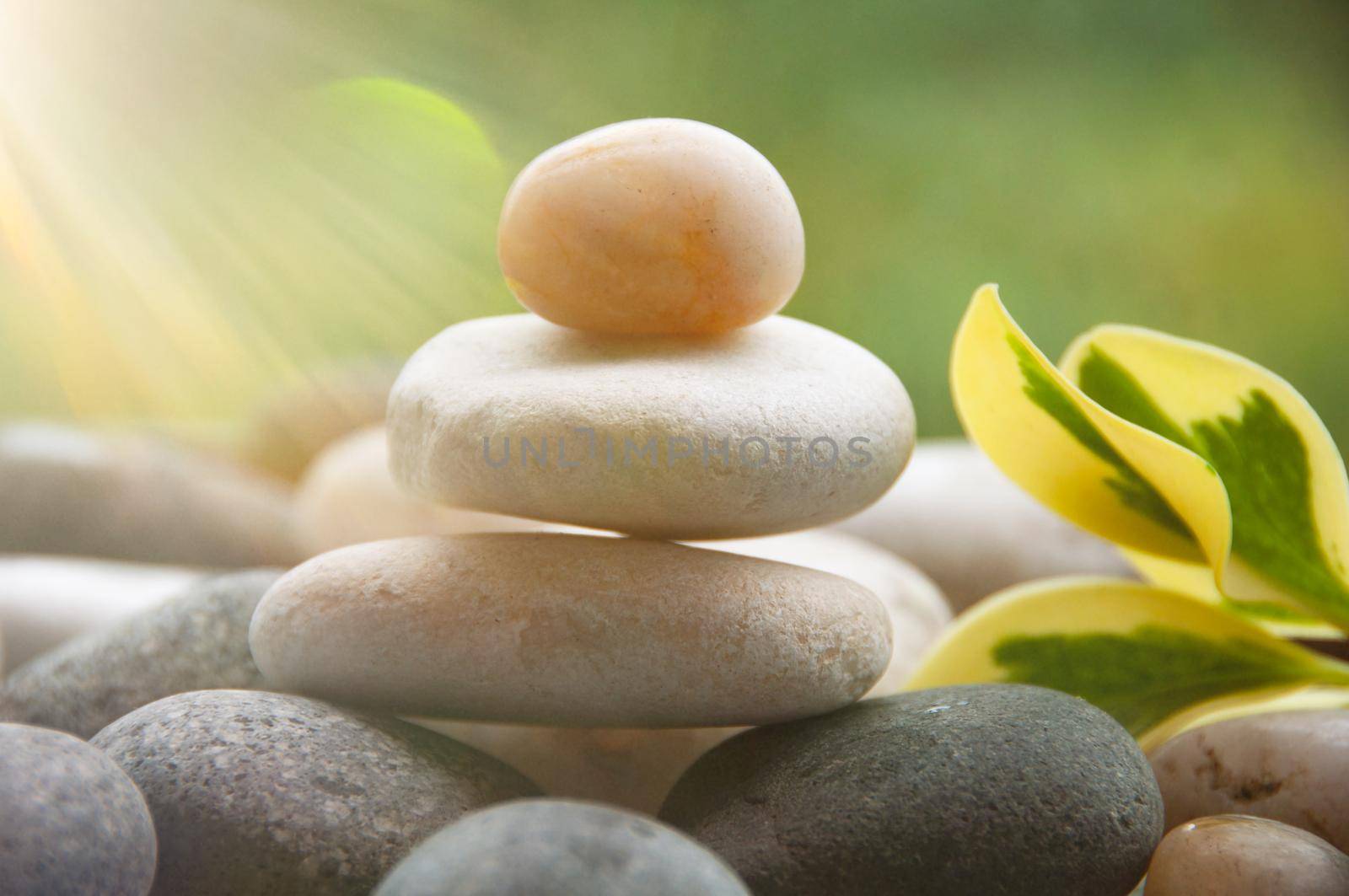 Light shining on zen stones with customizable space for text. Copy space and zen concept.