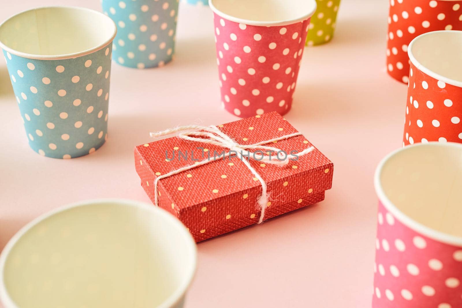 Flat lay composition with bright pink gift box, drink straws, ribbon and confetti. 