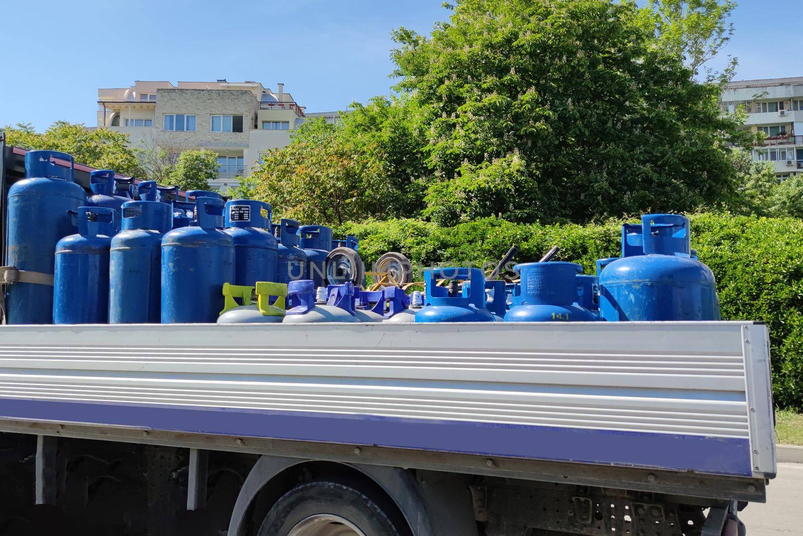 truck carries blue gas cylinders in an open body close up