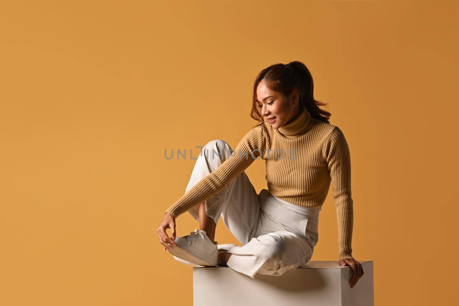 Fashionable woman wearing warm clothes posing isolated on yellow background. Fashion, beauty concept.