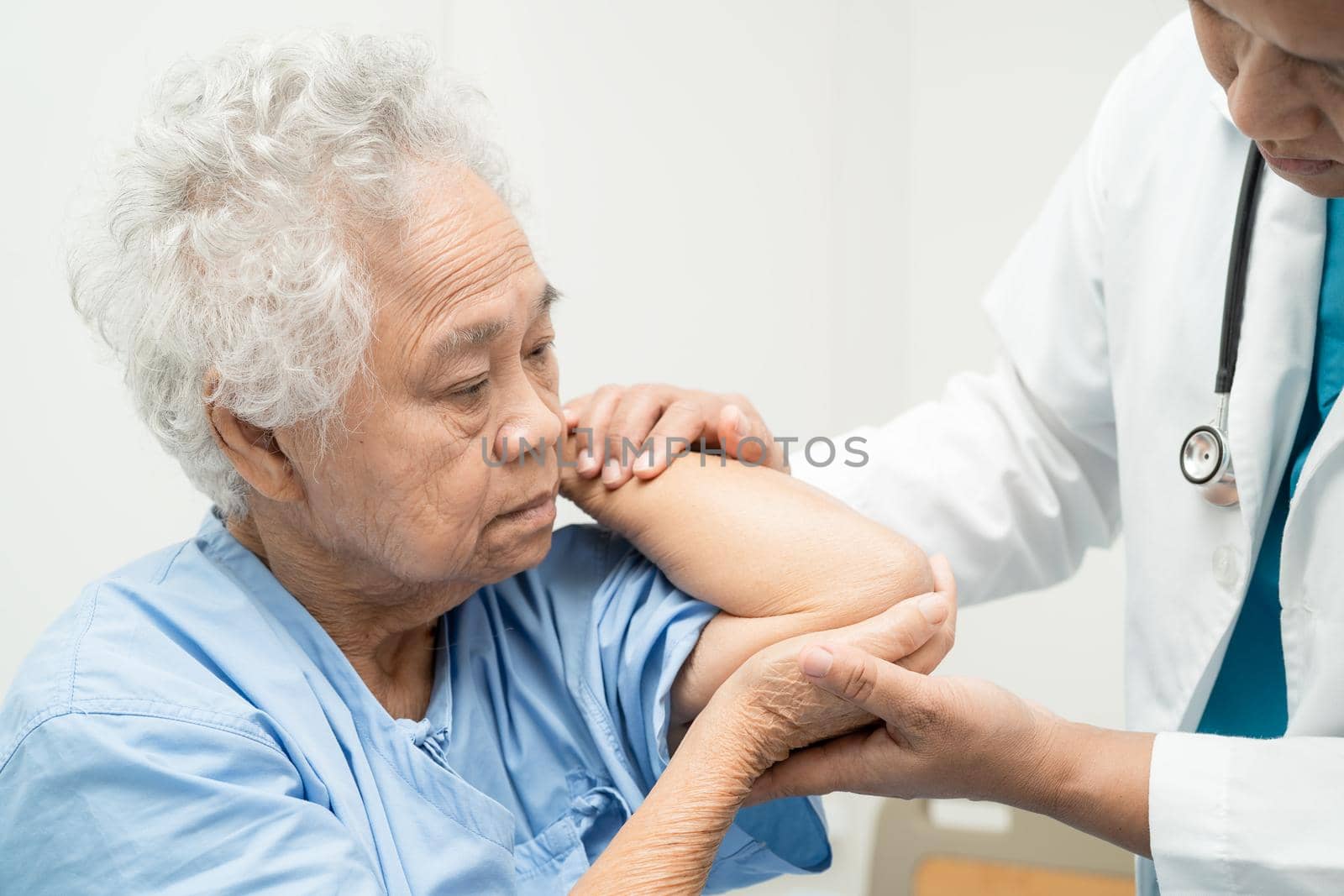 Asian senior or elderly old lady woman patient feel pain her elbow on bed in nursing hospital ward, healthy strong medical concept.