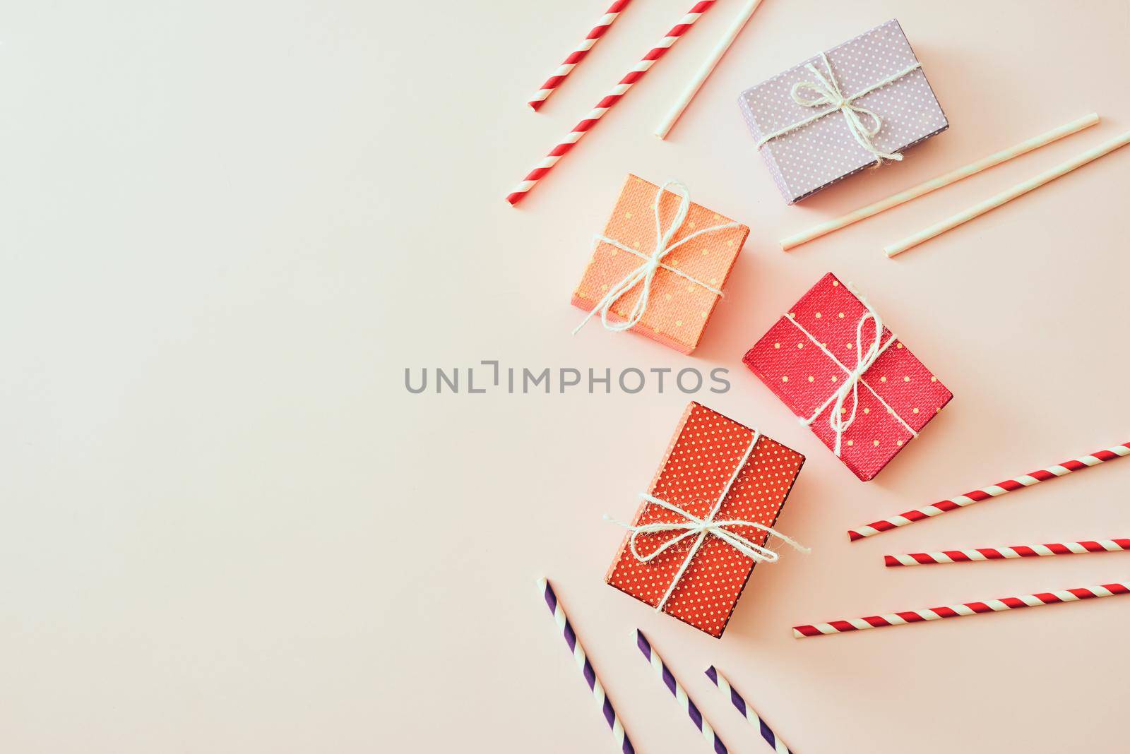 Different holiday colorful gift boxes wrapped in colorful paper and bows on beige background. by makidotvn