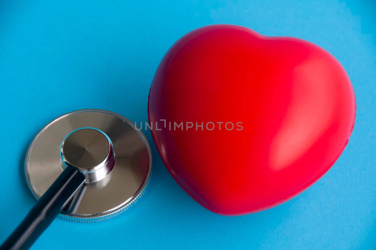 Stethoscope with heart shapes on light blue background. Health concept.