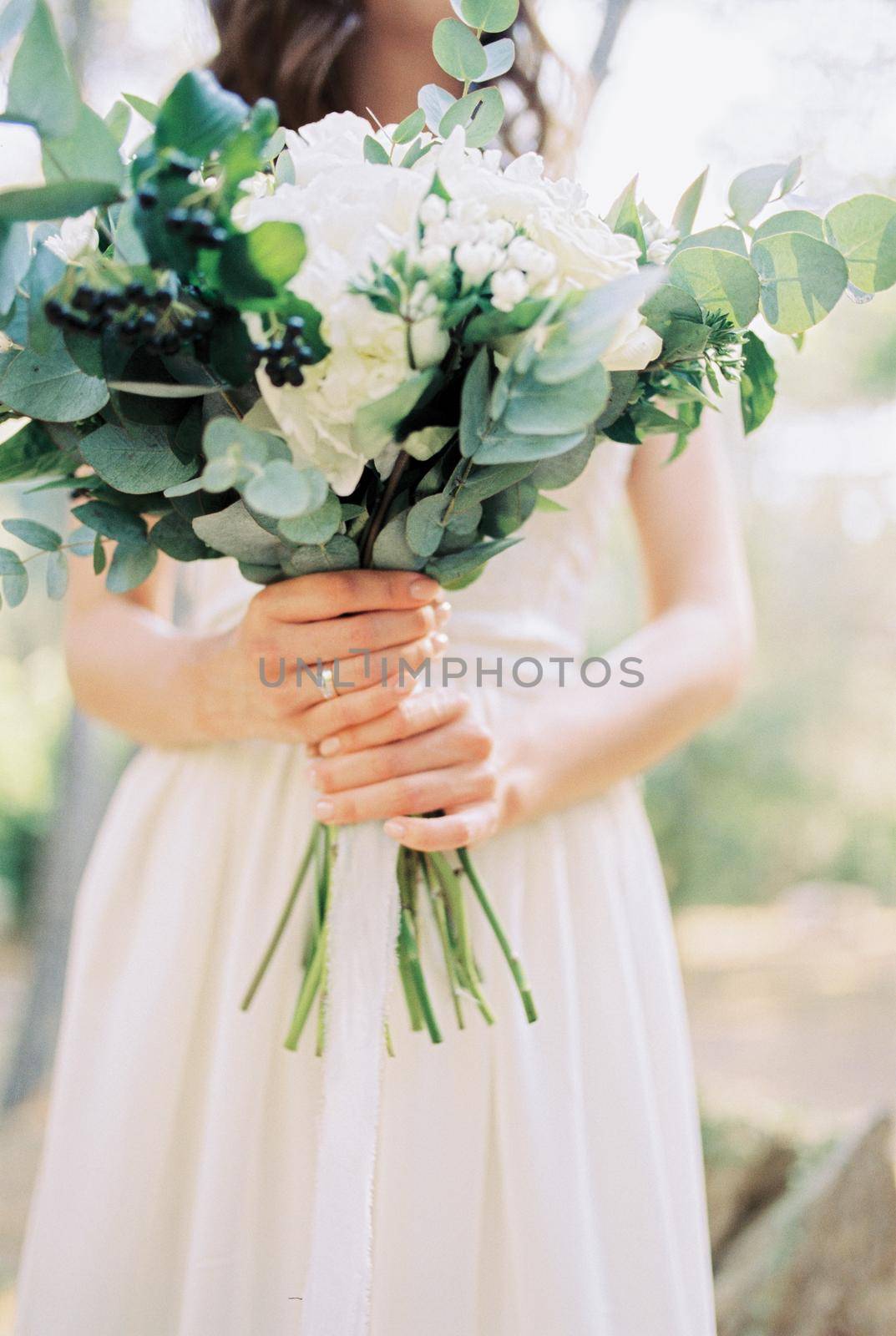 Bouquet of flowers in the hands of the bride. Cropped. High quality photo