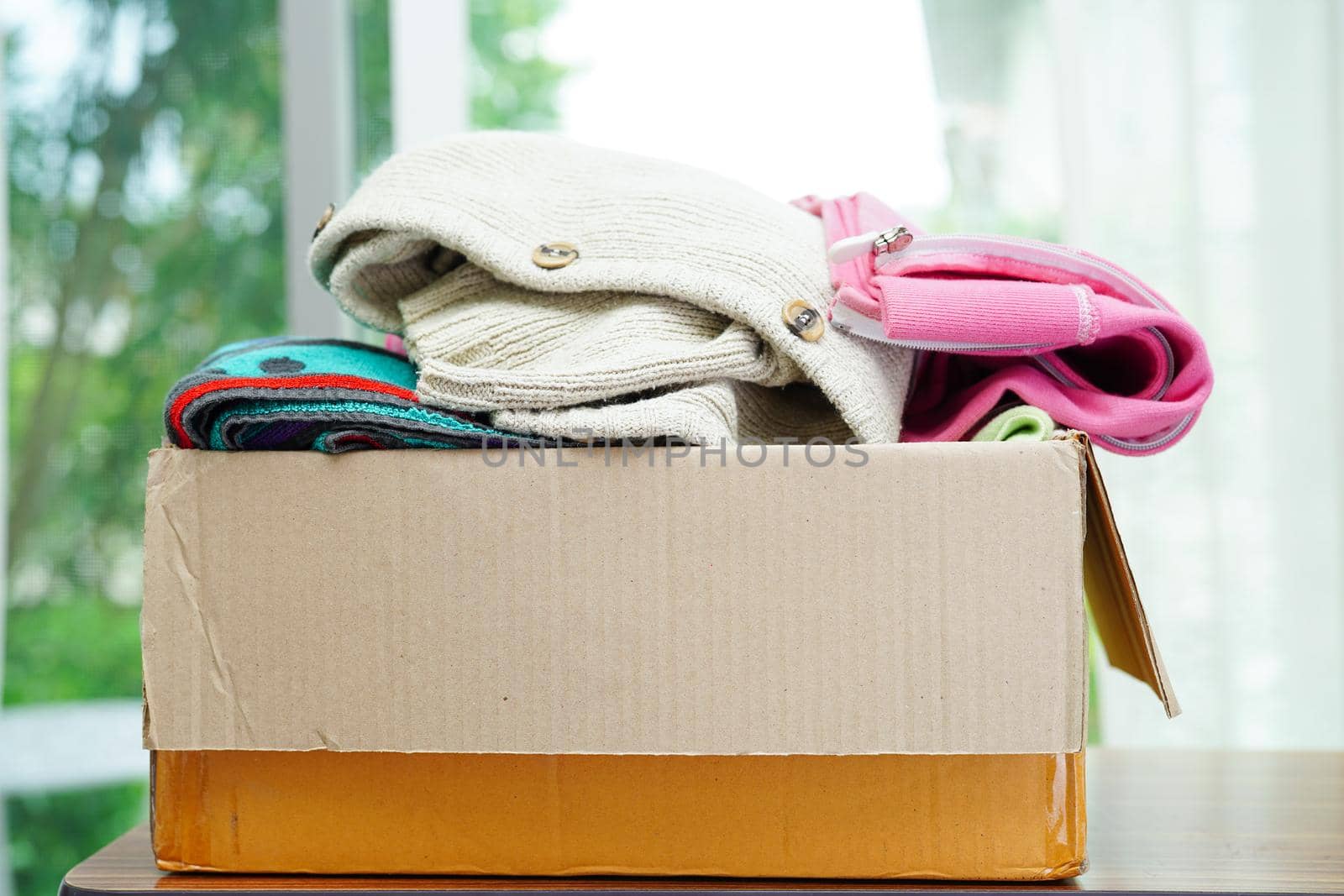 Clothes donations in cardboard box for volunteer.