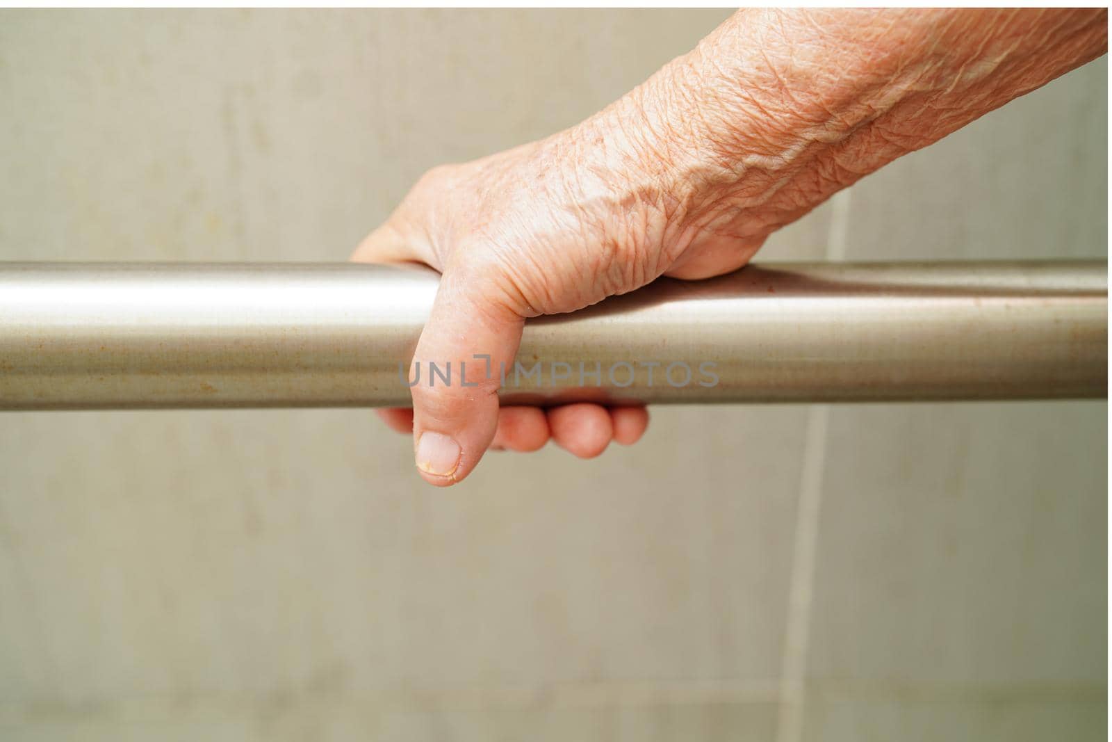 Asian elderly old woman patient use toilet support rail in bathroom, handrail safety grab bar, security in nursing hospital.
