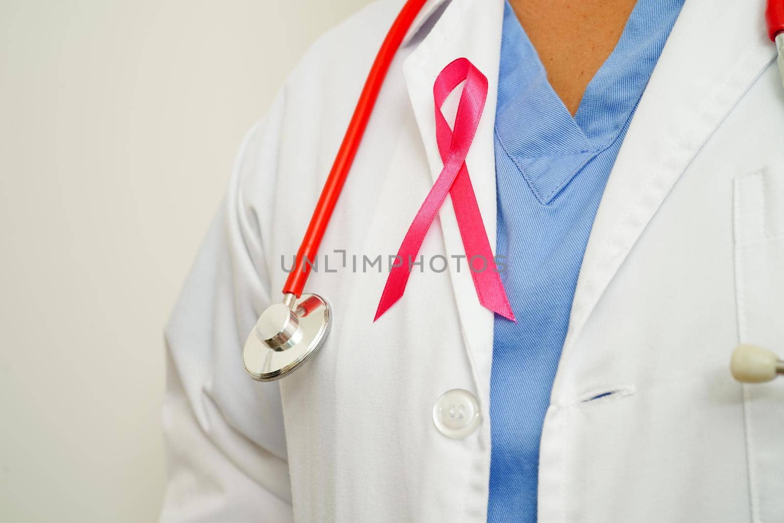 Asian woman doctor with pink ribbon, World Breast Cancer Day at October.