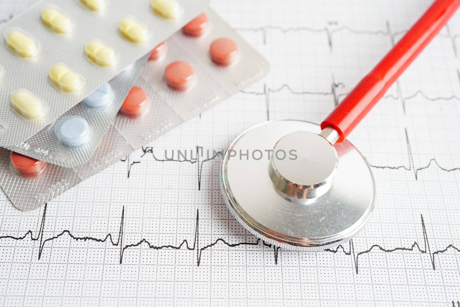 Stethoscope on electrocardiogram (ECG) with drug, heart wave, heart attack, cardiogram report.