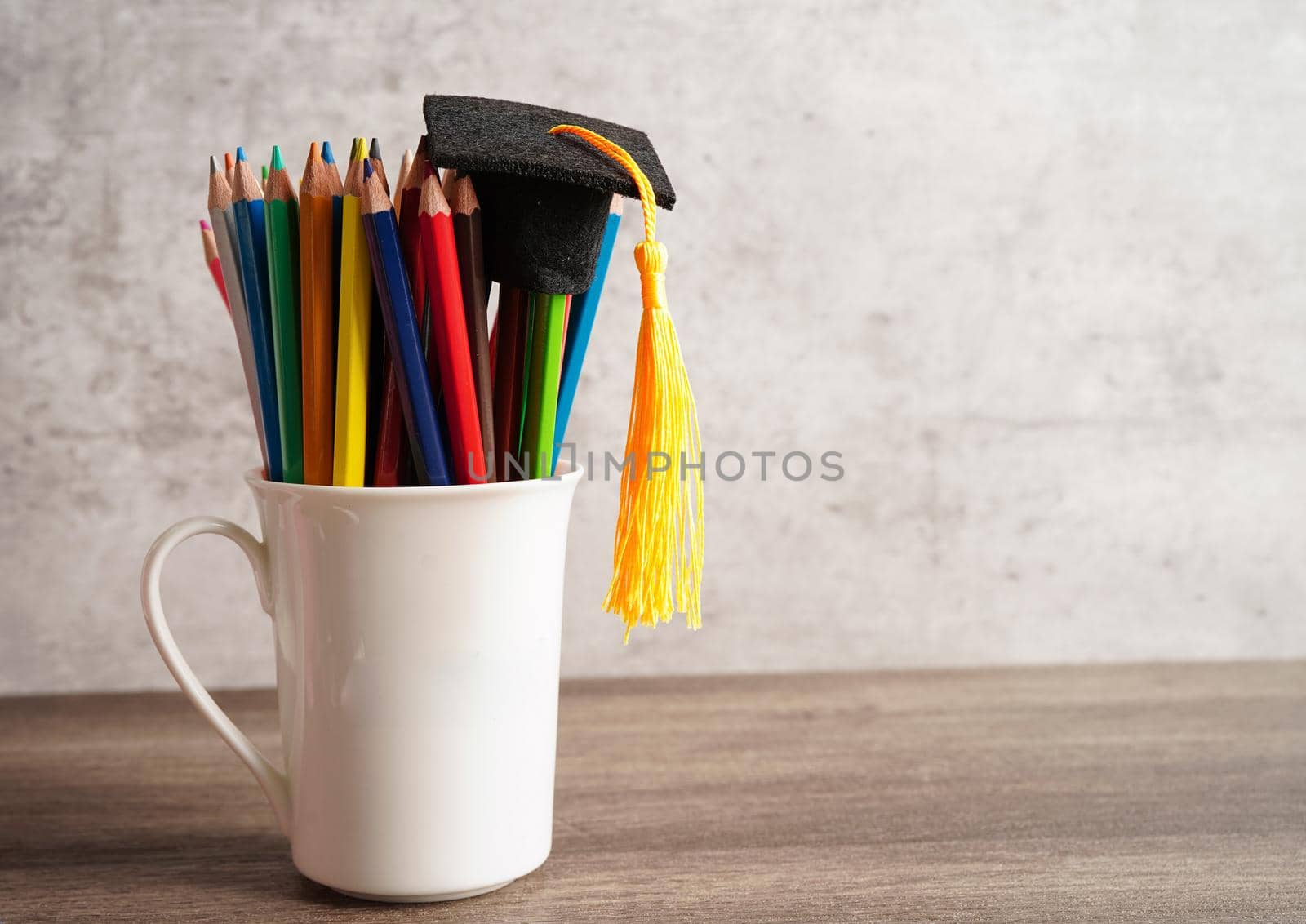 Graduation hat with colorful pencils on book with copy space, learning university education concept.