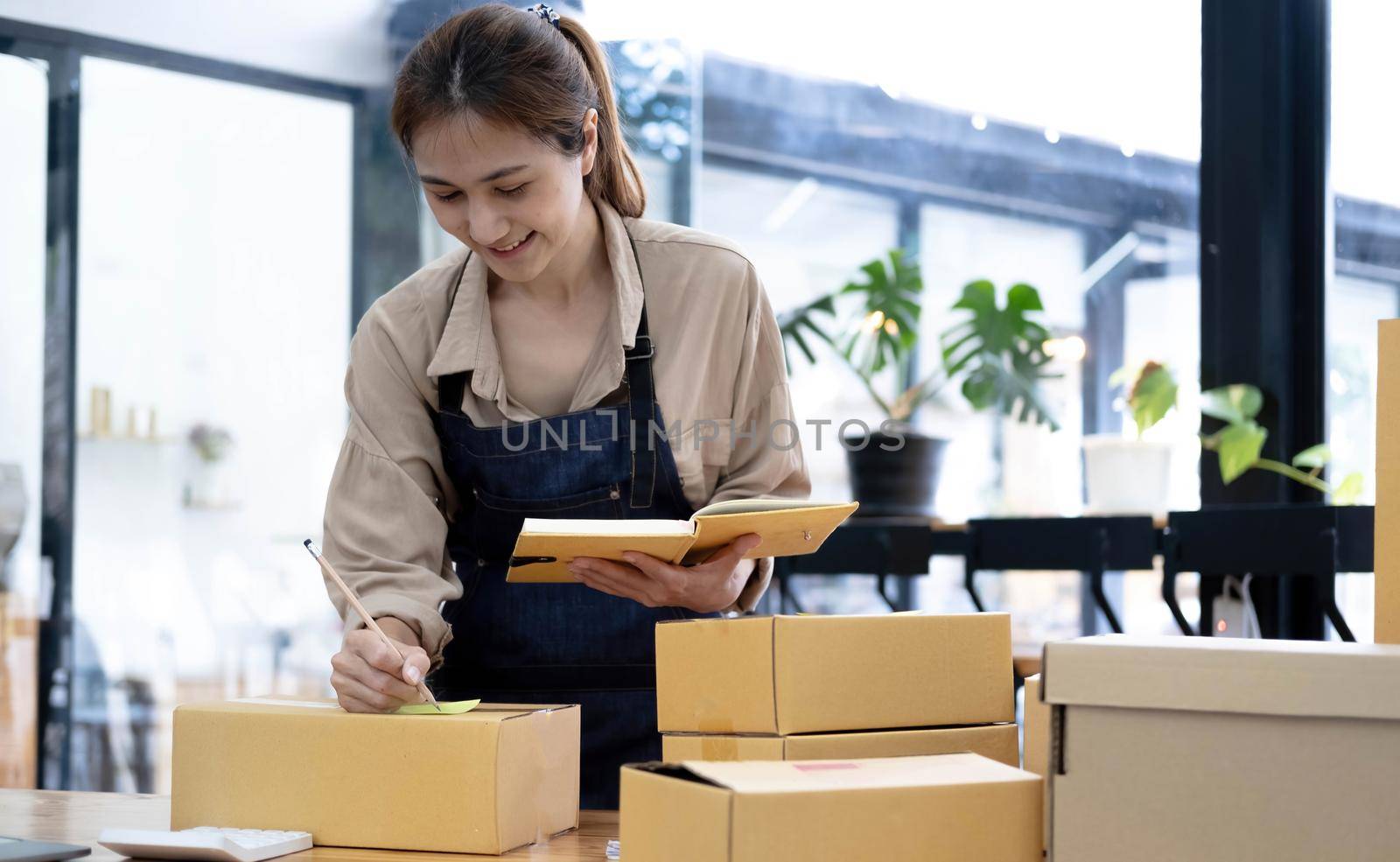 Asian woman writing clipboard, home delivery, SME e-commerce concept , Home online business , Delivery concept by wichayada