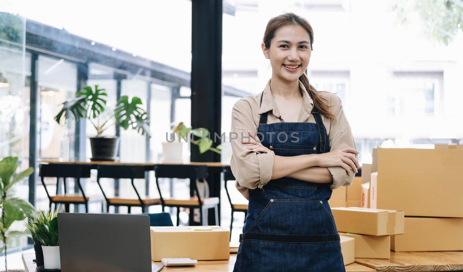 Portrait of Asian young woman SME working with a box at home the workplace.start-up small business owner, small business entrepreneur SME or freelance business online and delivery concept..