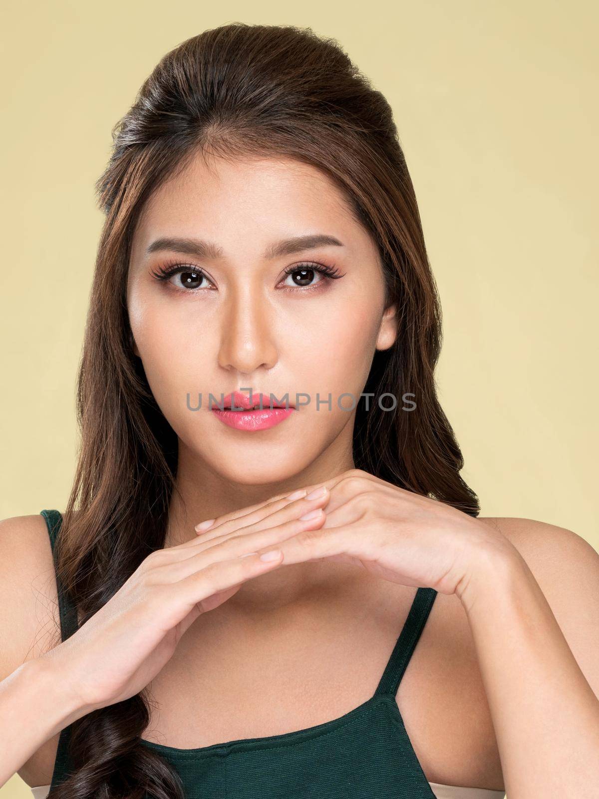 Portrait of ardent young girl with healthy clear skin and soft makeup looking at camera and posing beauty gesture. Cosmetology and beauty concept.