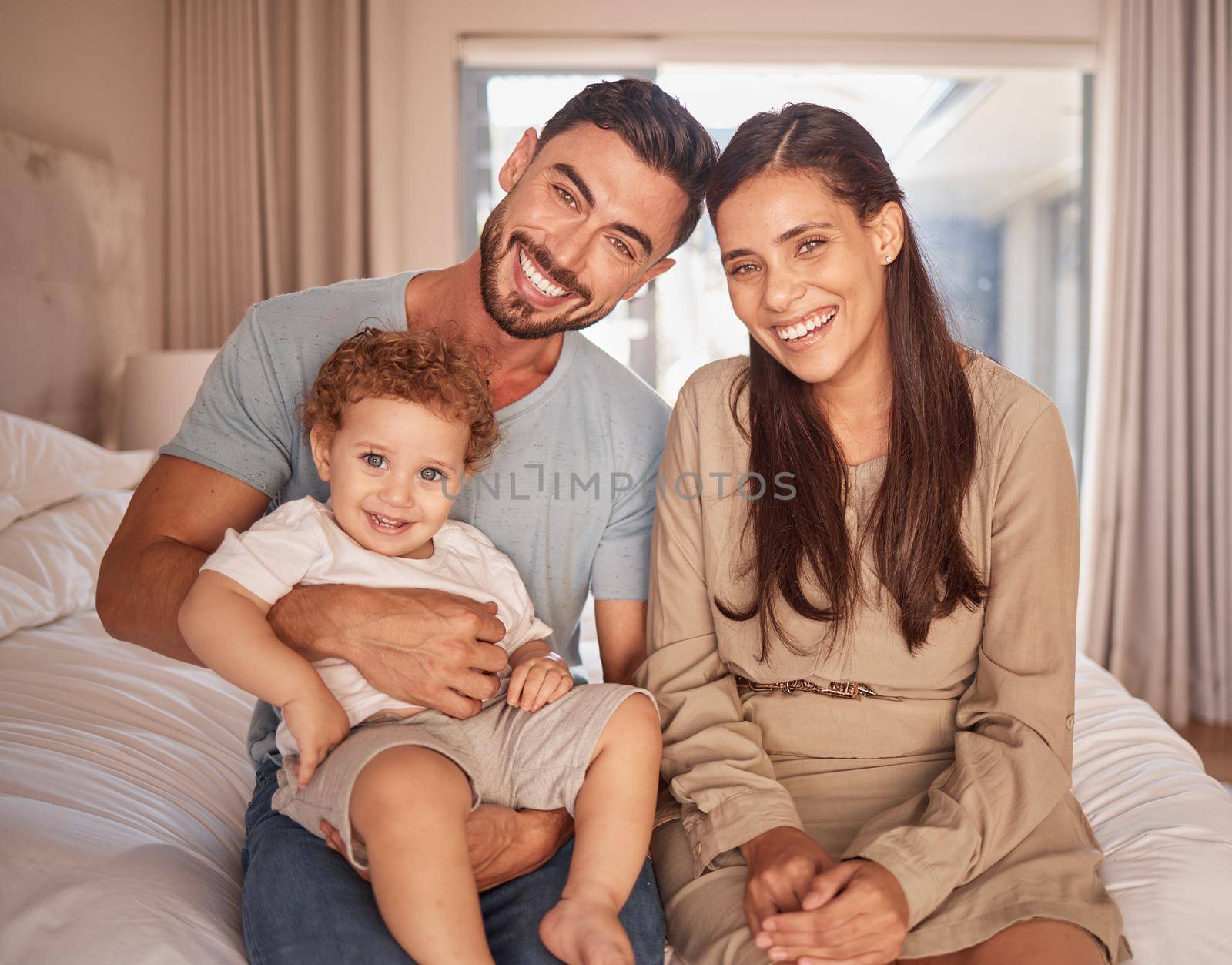 Mom, dad and baby on bed with smile in room together at home in Miami. Parents, bedroom and happy child bonding in bedroom show love in portrait of family in house, apartment or hotel to relax by YuriArcurs