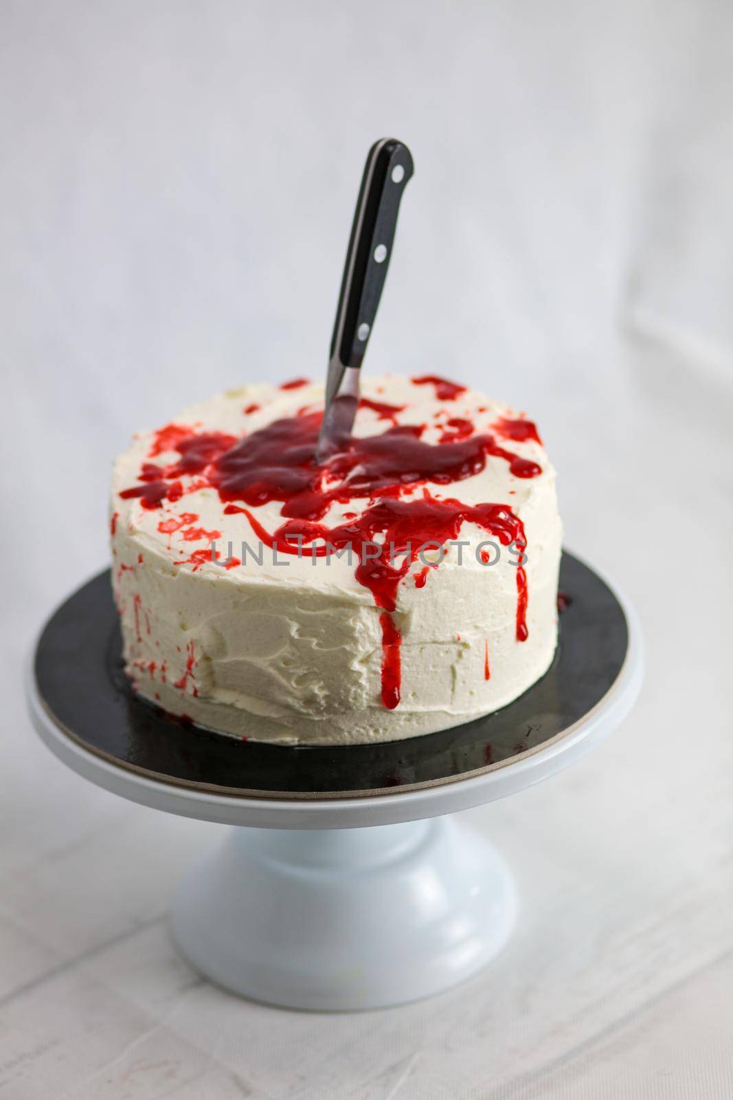 designer chef decorating white red bloody horror crime cake for halloween party by verbano