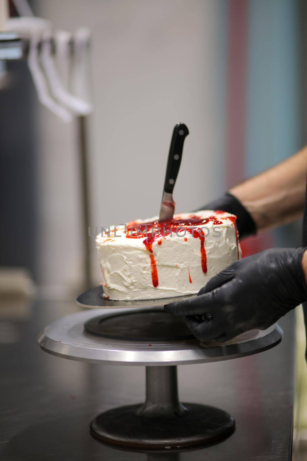designer chef decorating white red bloody horror crime cake for halloween party by verbano