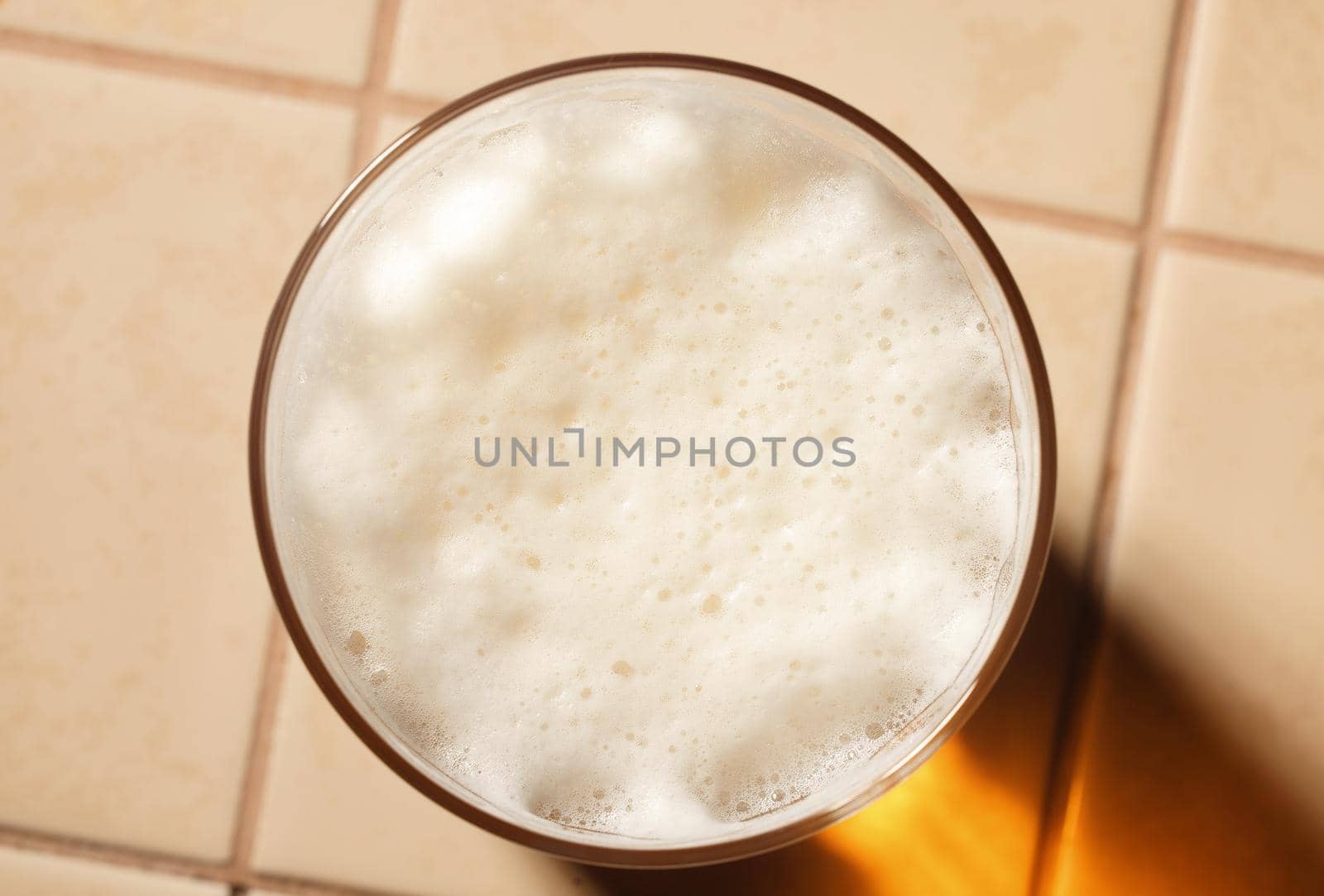 Glass of fresh lager beer with White fresh Foam on table. Beer foam top view. Bubble froth of beer by EvgeniyQW