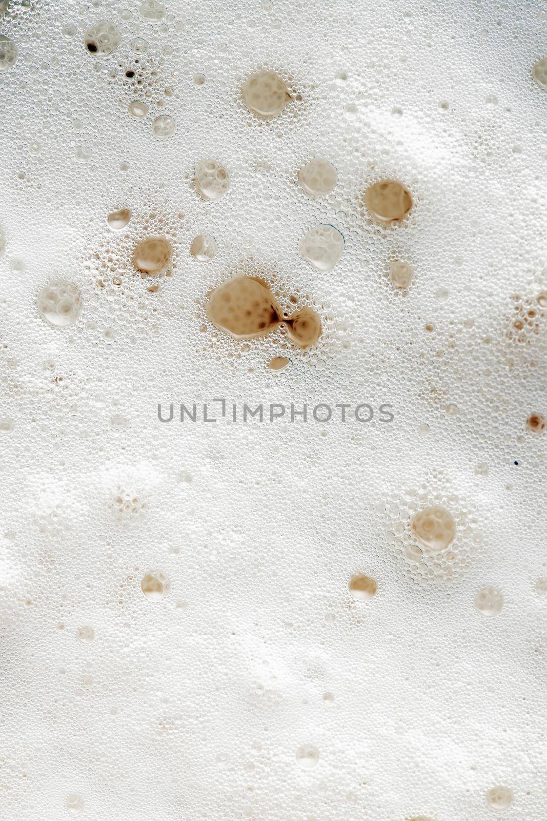 Beer foam top view. Soft fresh Foam on light beer. Bubble froth of beer. Beer foam texture background.