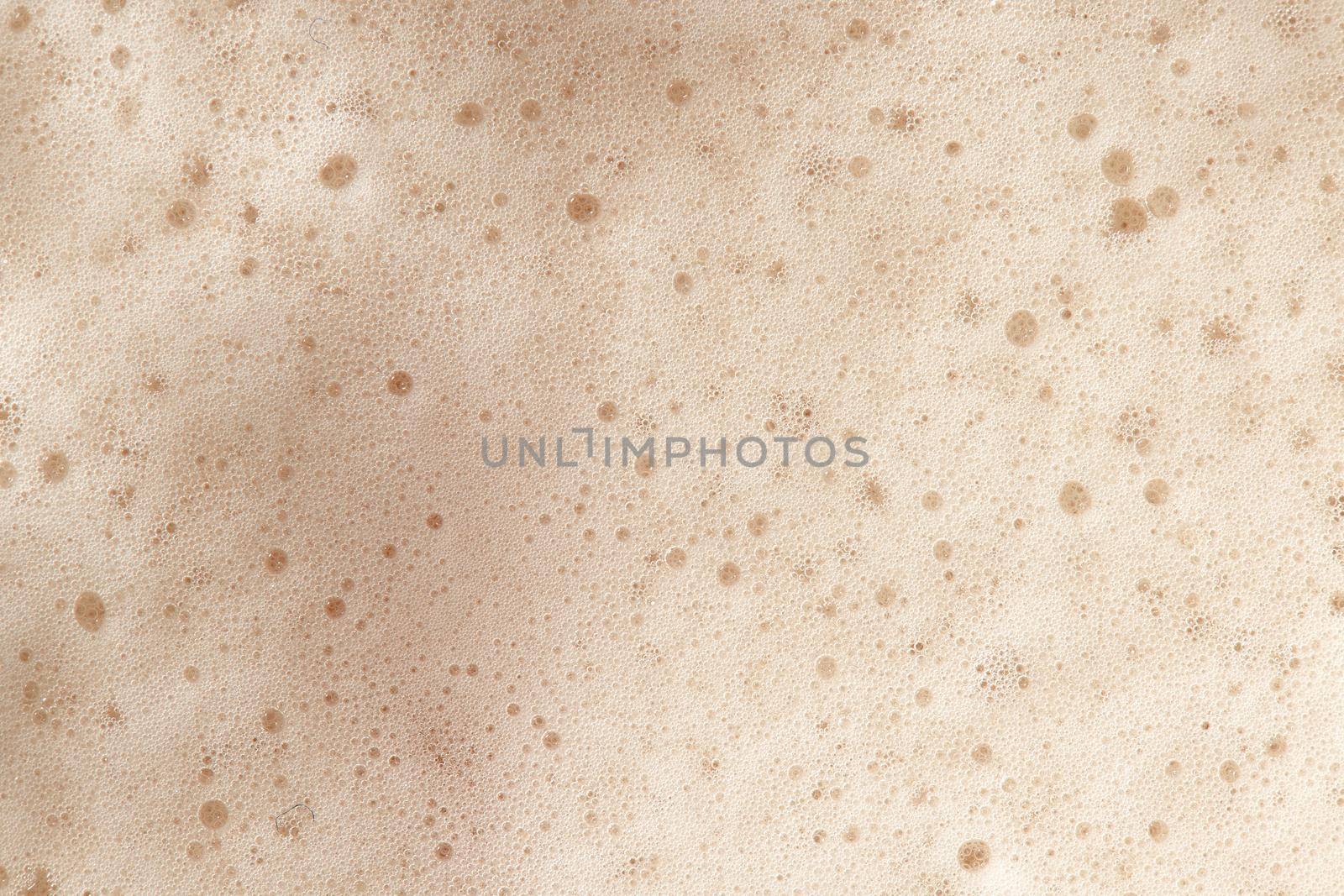 Beer foam top view. Soft fresh Foam on light beer. Bubble froth of beer. Beer foam texture background.