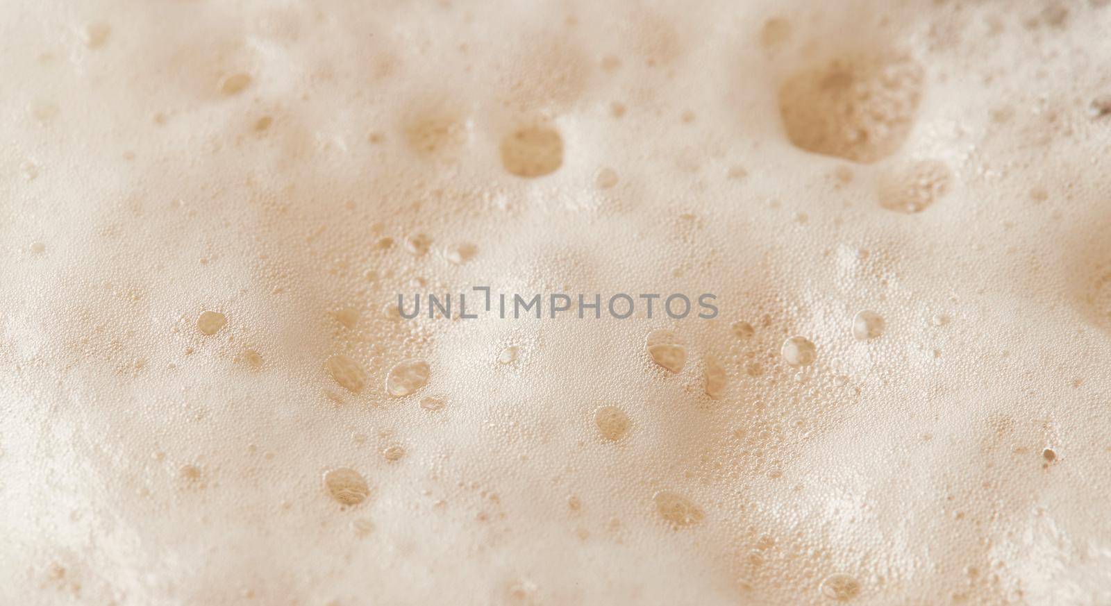 Beer foam top view. Soft fresh Foam on light beer. Bubble froth of beer. Beer foam texture background.