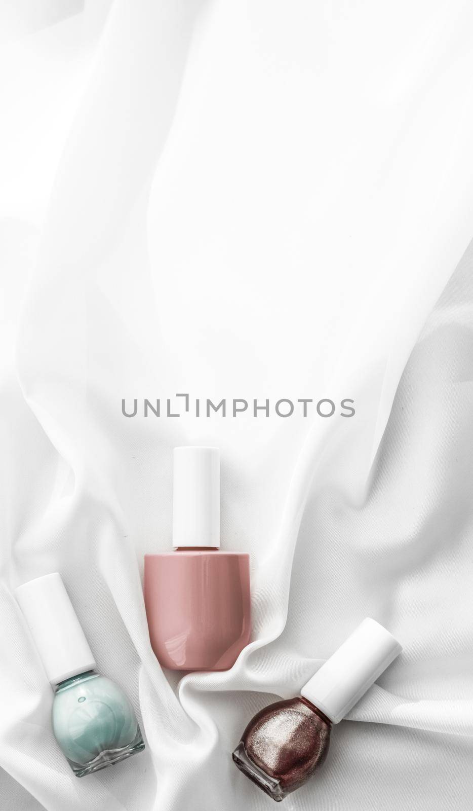 Cosmetic branding, salon and glamour concept - Nail polish bottles on silk background, french manicure products and nailpolish make-up cosmetics for luxury beauty brand and holiday flatlay art design