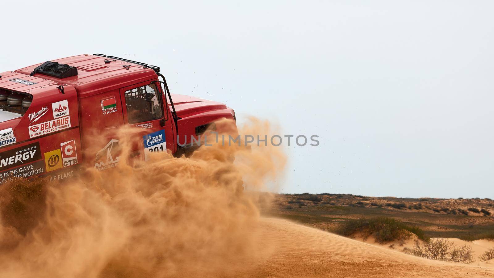 The rivalry between Kamaz and Maz at the rally. Sports truck KAMAZ gets over the difficult part of the route during the Rally raid in sand. THE GOLD OF KAGAN-2021. 26.04.2021 Astrakhan, Russia.