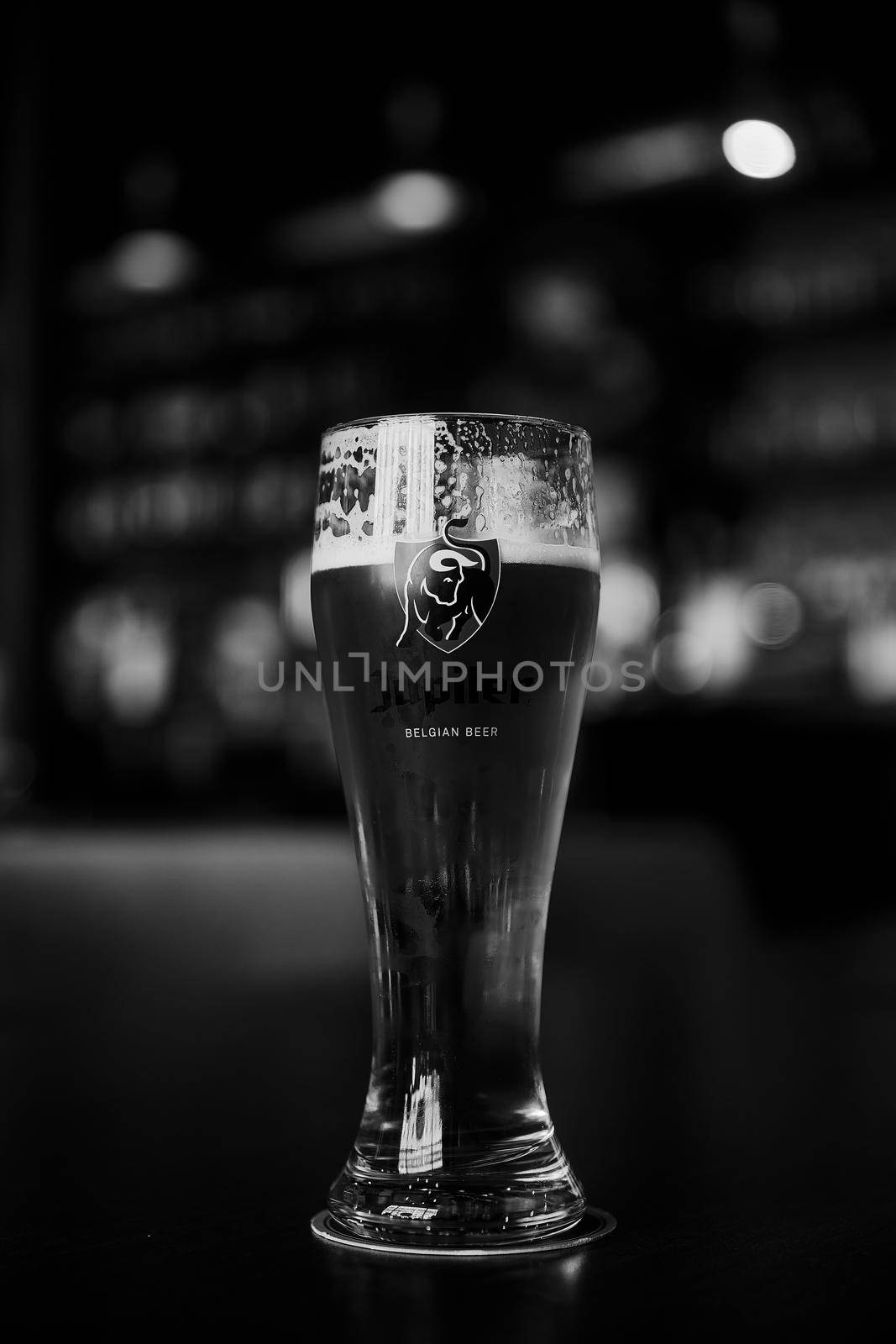 Glass of Belgian Jupiler beer. glass of beer on a table in a bar on blurred bokeh background. Saint Petersburg, Russia, 19,06,2021.