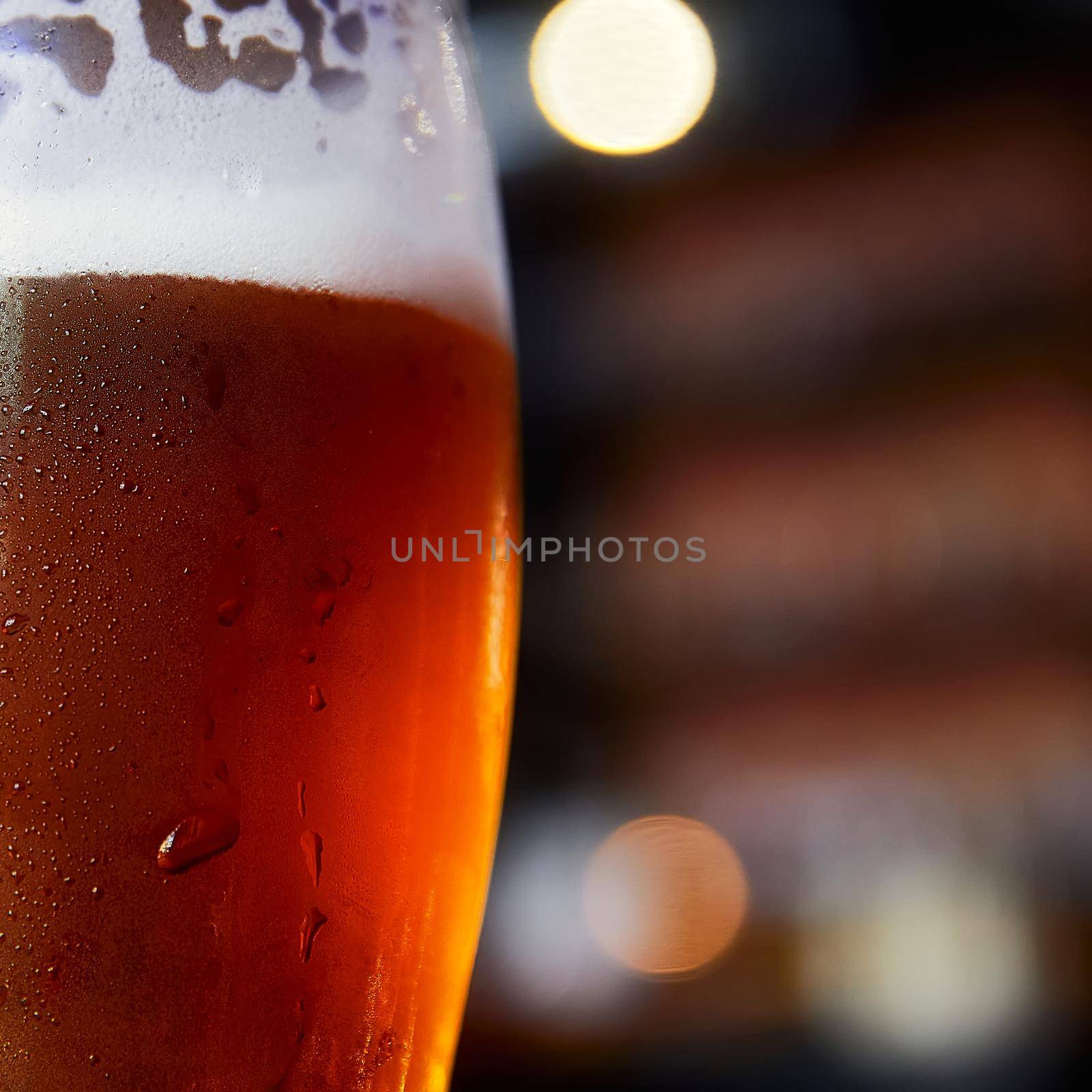 Glass of beer on a table in a bar on blurred bokeh background by EvgeniyQW