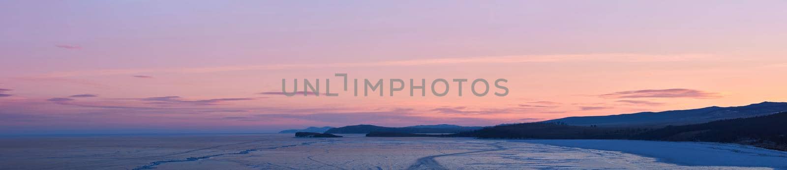 Frozen lake Baikal, at dawn. Winter landscape panorama