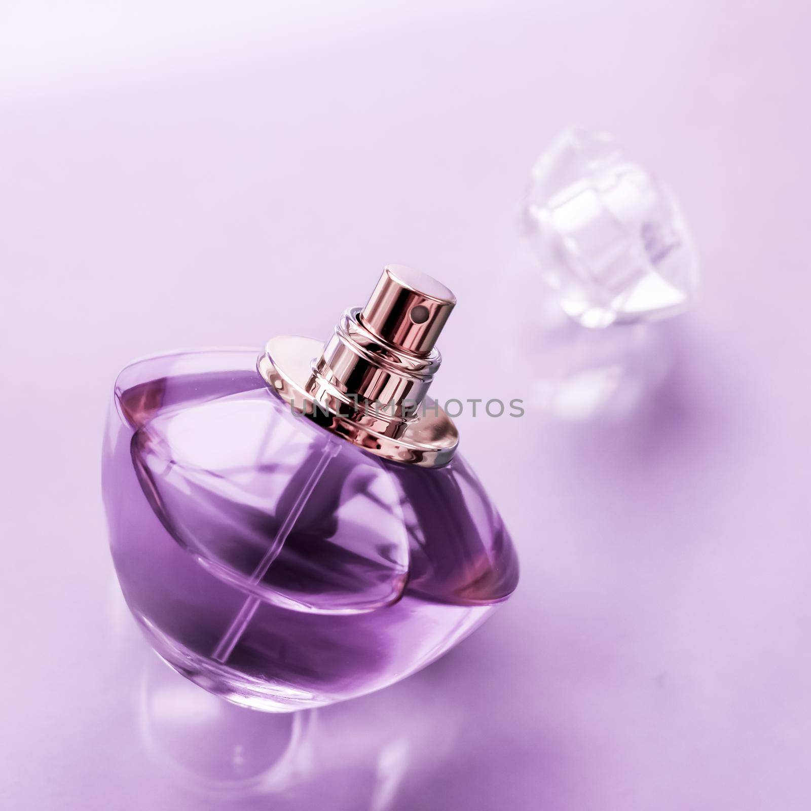 Perfumery, spa and branding concept - Purple perfume bottle on glossy background, sweet floral scent, glamour fragrance and eau de parfum as holiday gift and luxury beauty cosmetics brand design