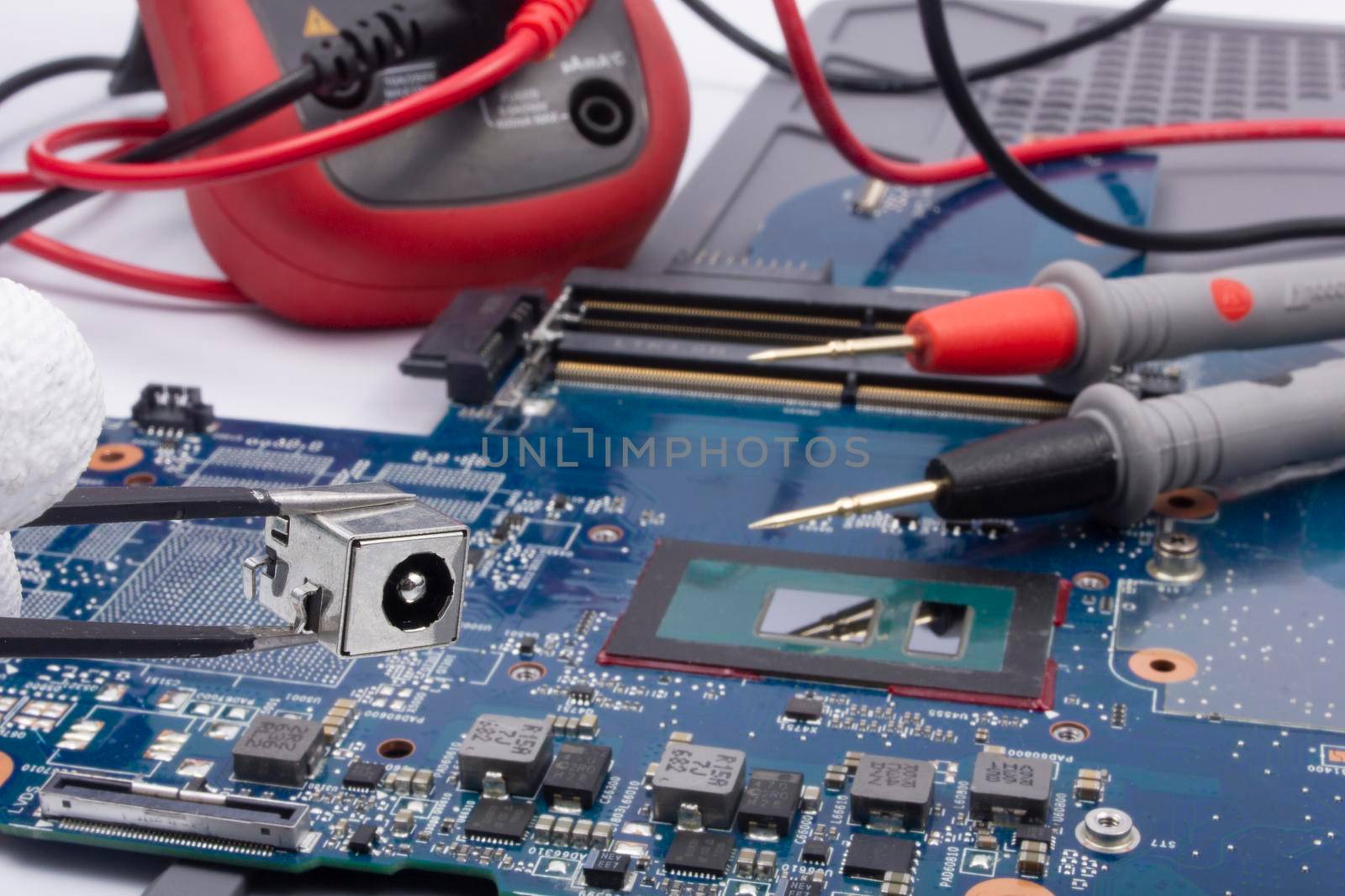 Computer repair service. Engineer repairing laptop mainboard.