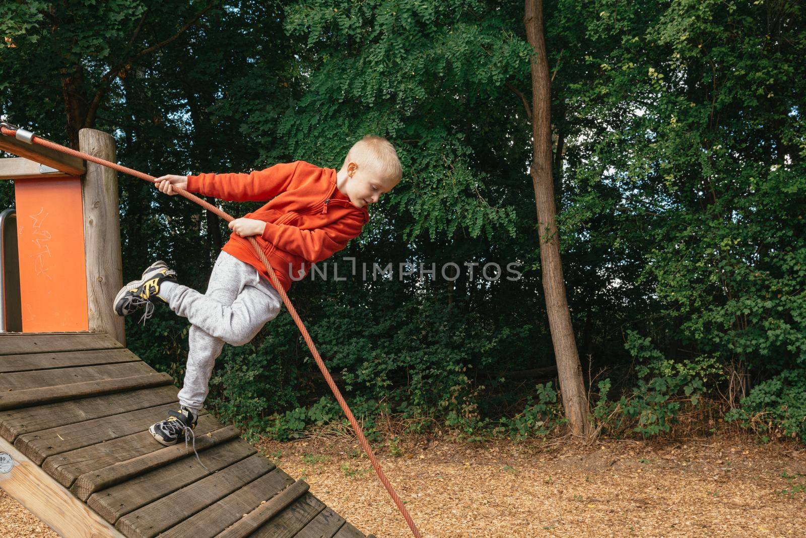 Funny cute happy baby playing on the playground. The emotion of happiness, fun, joy. Smile of a child. boy playing on the playground by Andrii_Ko