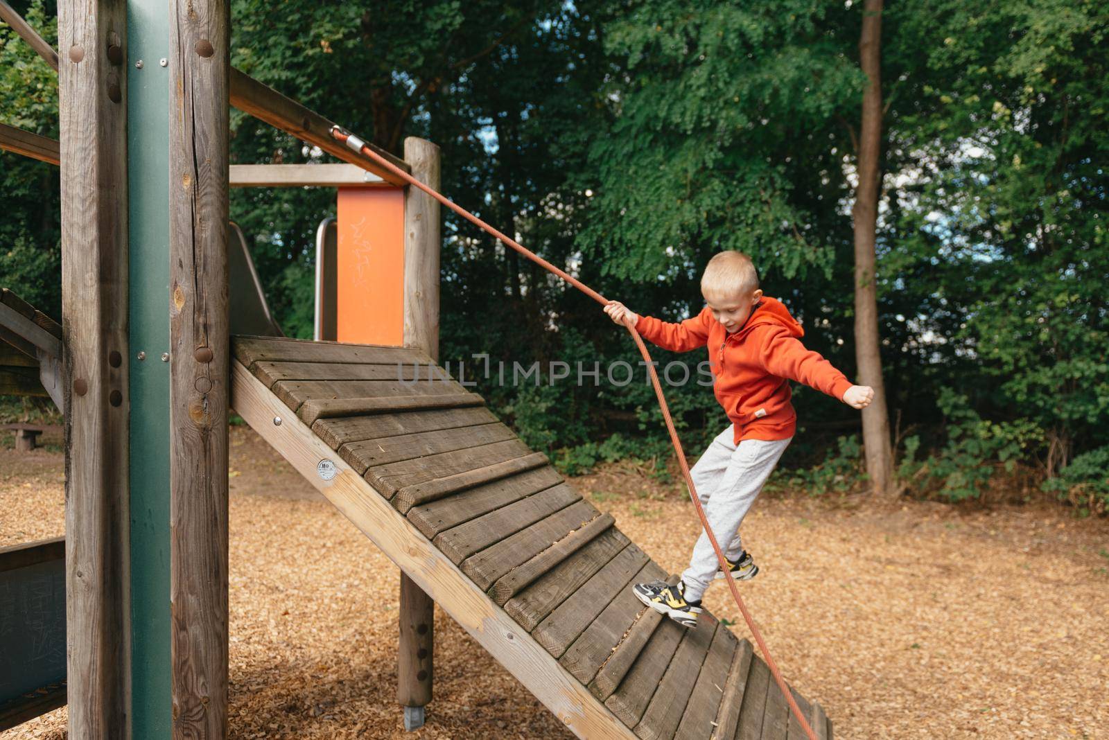 Funny cute happy baby playing on the playground. The emotion of happiness, fun, joy. Smile of a child. boy playing on the playground by Andrii_Ko