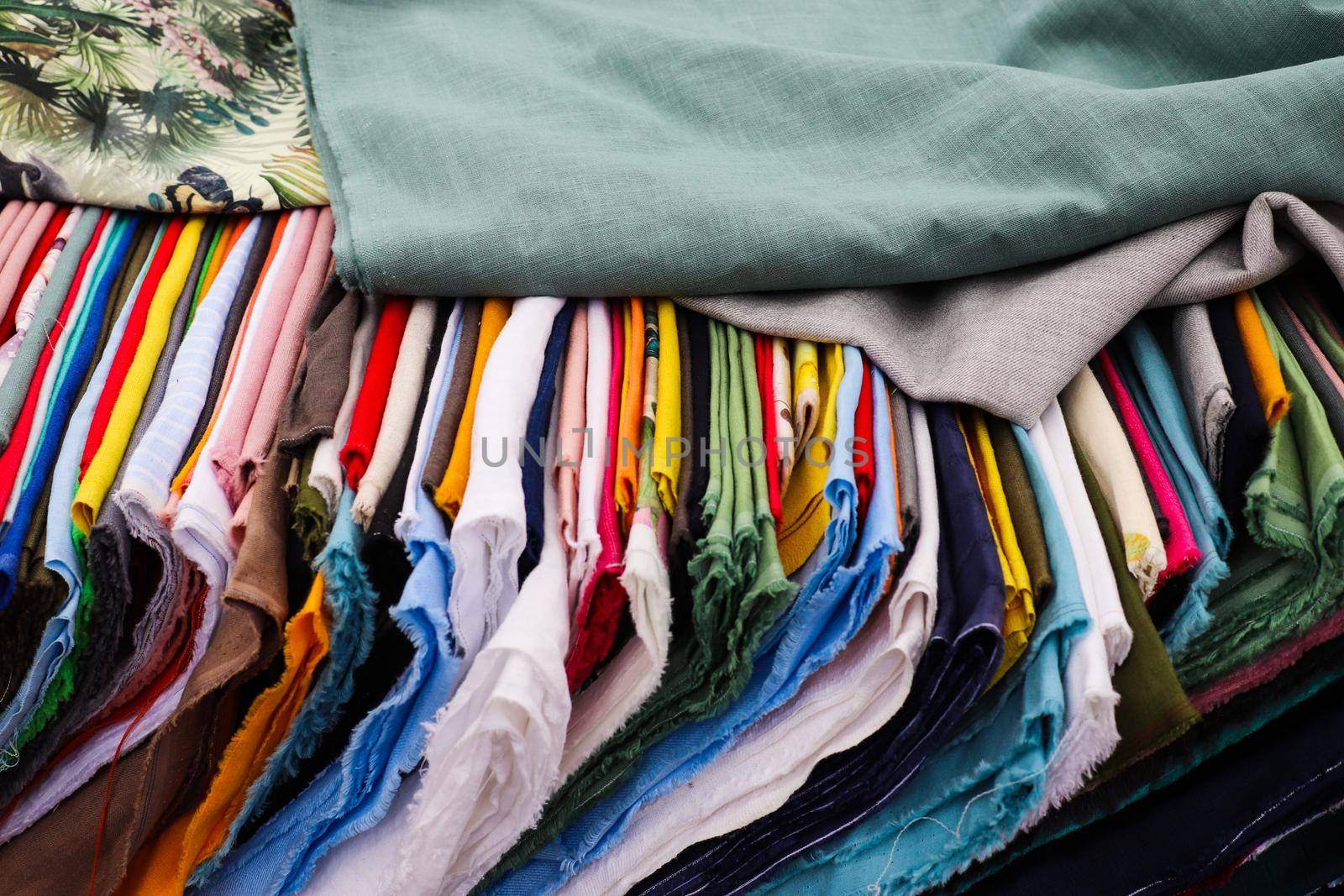 Detailed close up view on samples of cloth and fabrics in different colors found at a fabrics market.