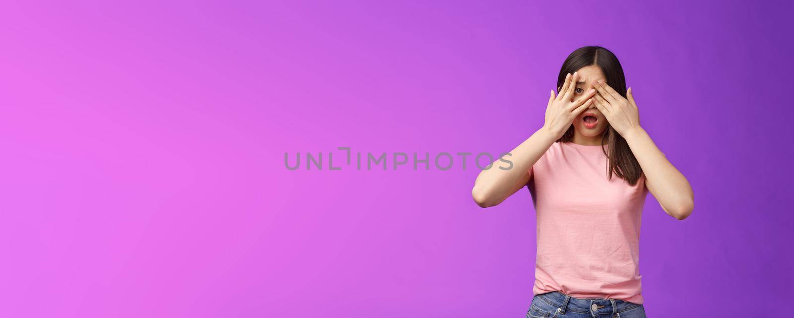 Shocked concerned asian girl witness terrible crime feel insecure scared, close eyes frightened shook, open mouth, gasping upset, standing stupor drop jaw, pose purple background. Copy space
