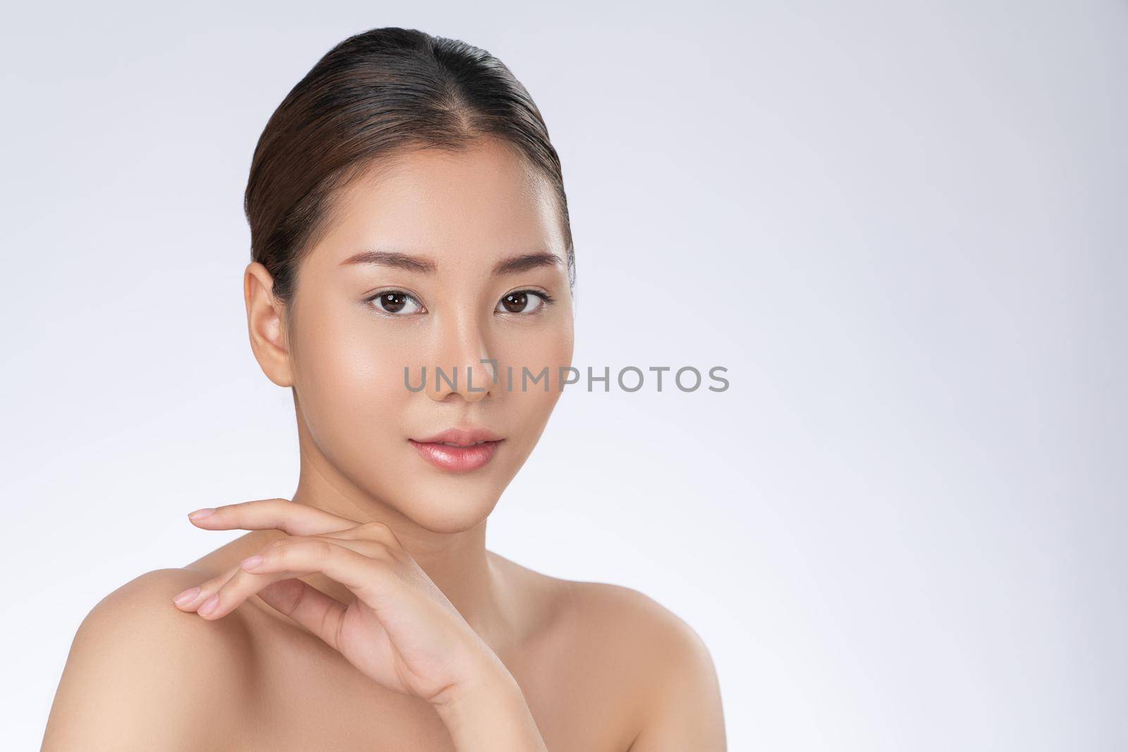 Portrait of gorgeous young girl posing beauty gesture with healthy clear skin and soft makeup. Cosmetology and beauty concept.