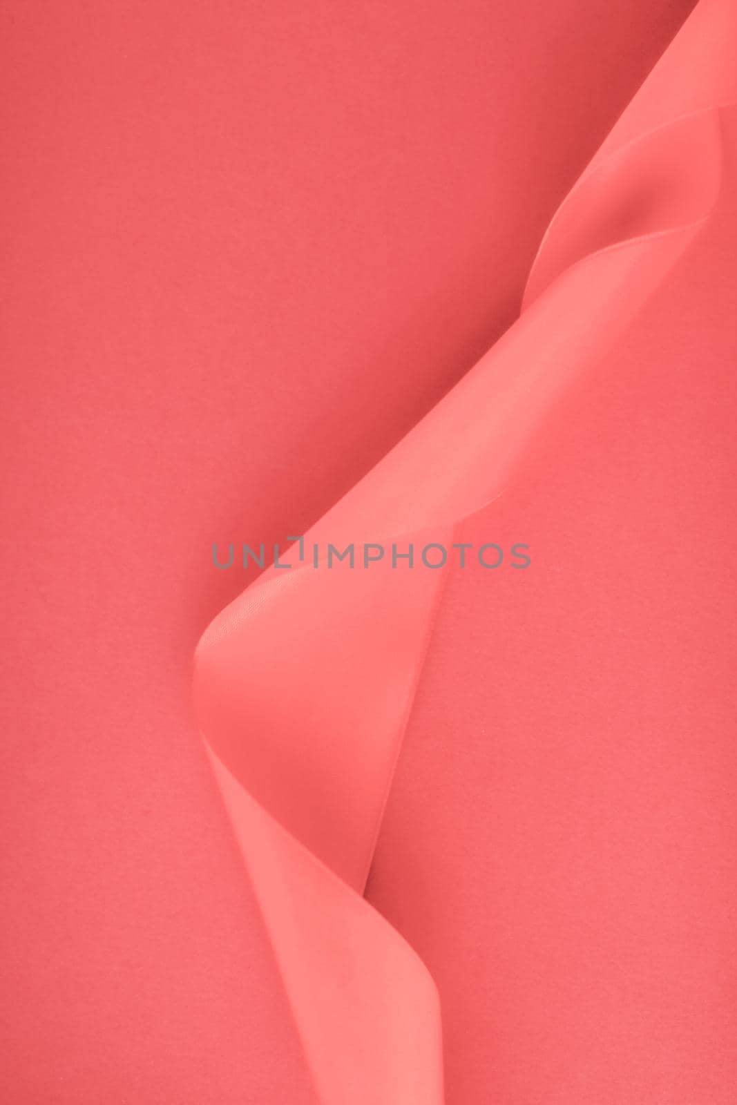 Branding, holidays and luxe brands concept - Abstract curly silk ribbon on coral background, exclusive luxury brand design for holiday sale product promotion and glamour art invitation card backdrop