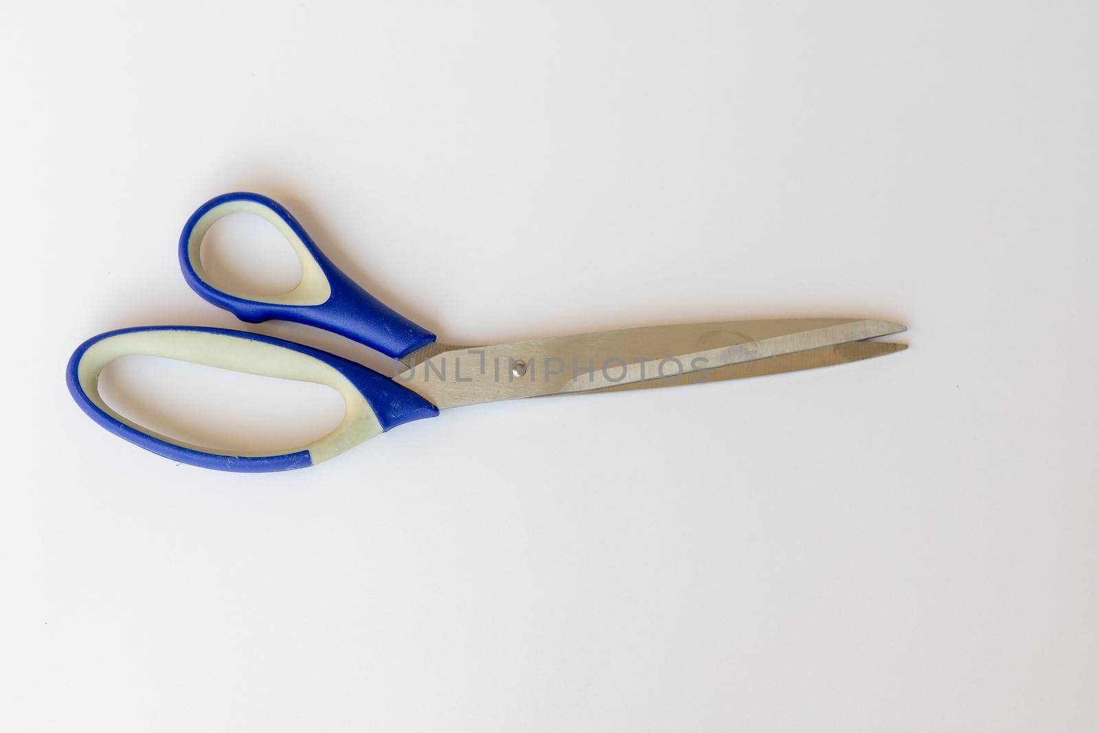 Scissors with blue handles on white isolated background