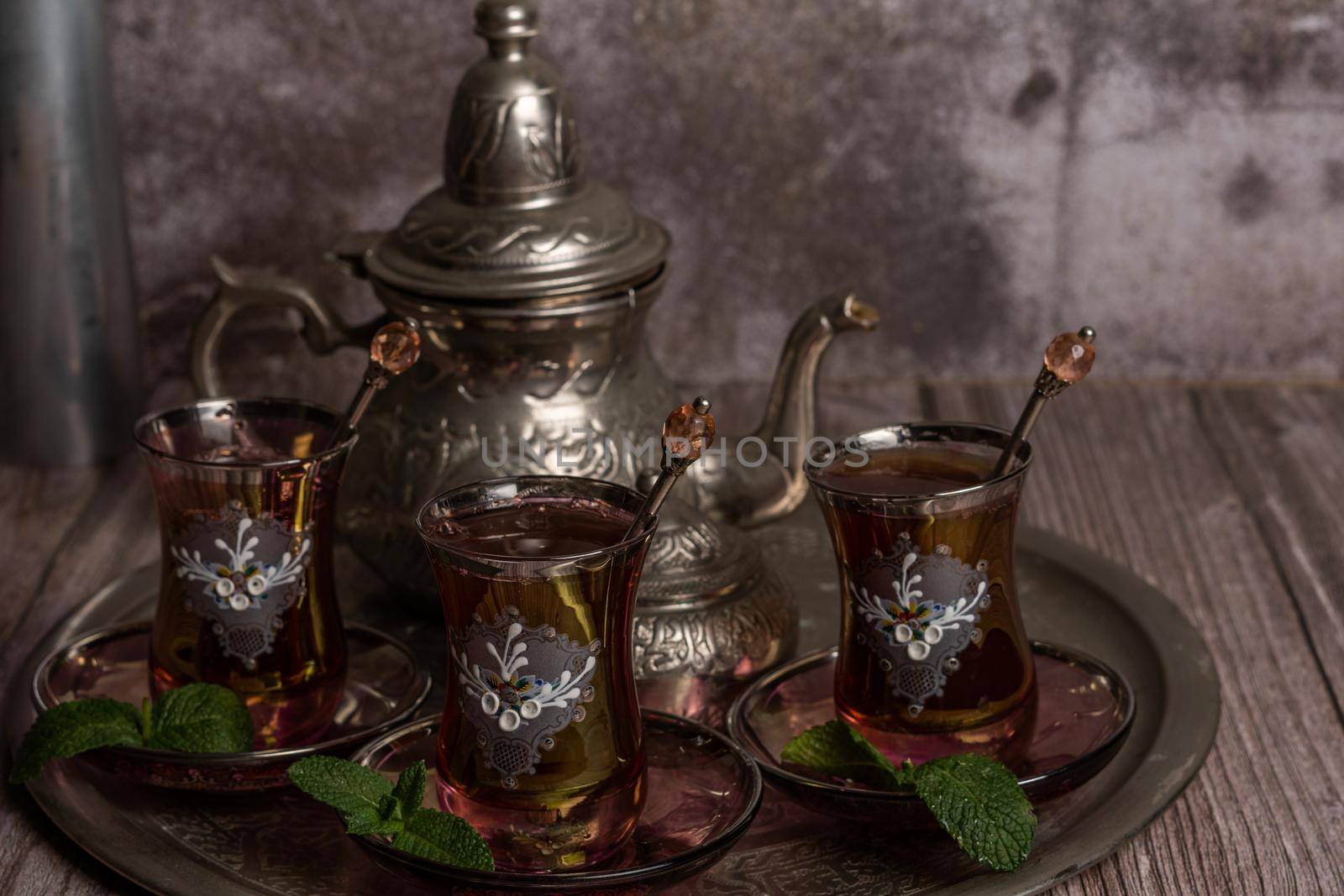 tray with glasses and serving pitcher of authentic Moorish tea ready to drink with mint leaves