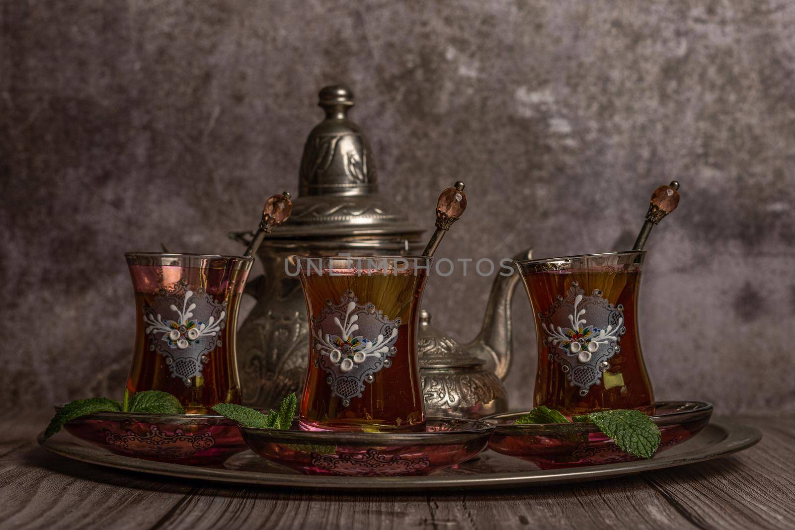 tray with glasses and serving pitcher of authentic Moorish tea ready to drink with mint leaves