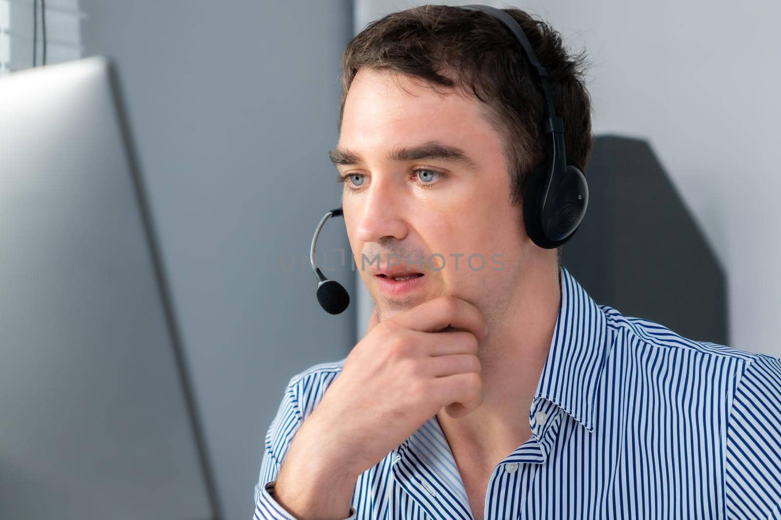 Competent male operator working with customers in the office. Concept of an operator, customer service agent working in the office.