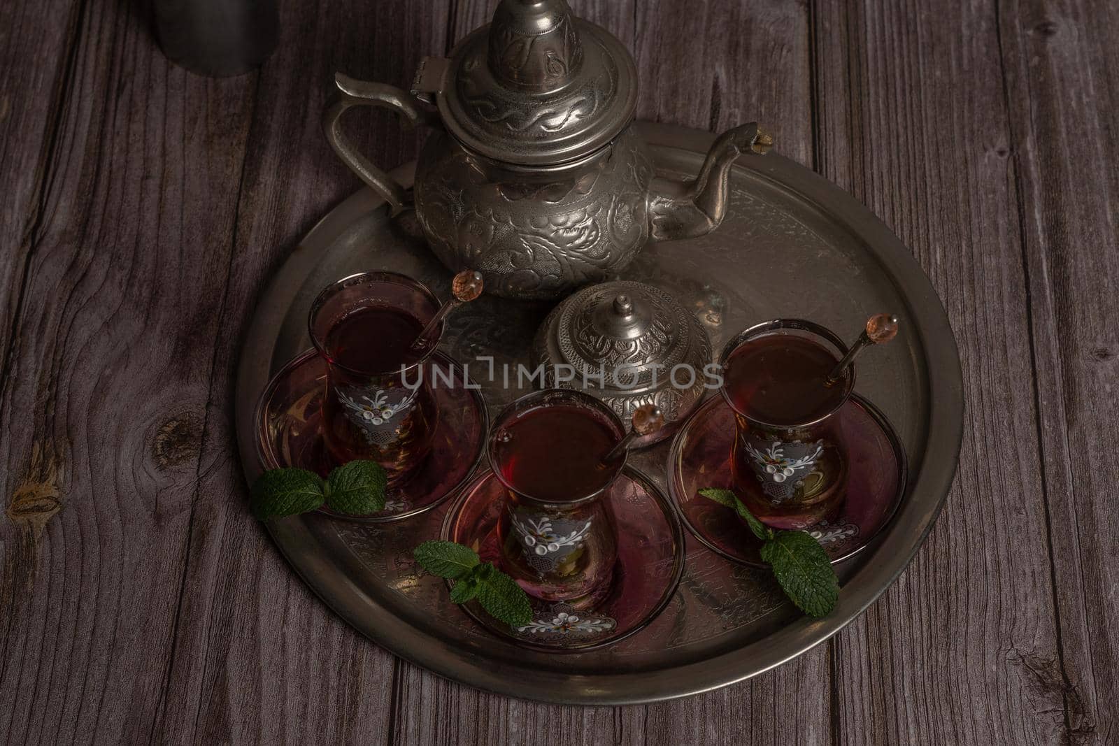 tray with glasses and serving pitcher of authentic Moorish tea ready to drink with mint leaves