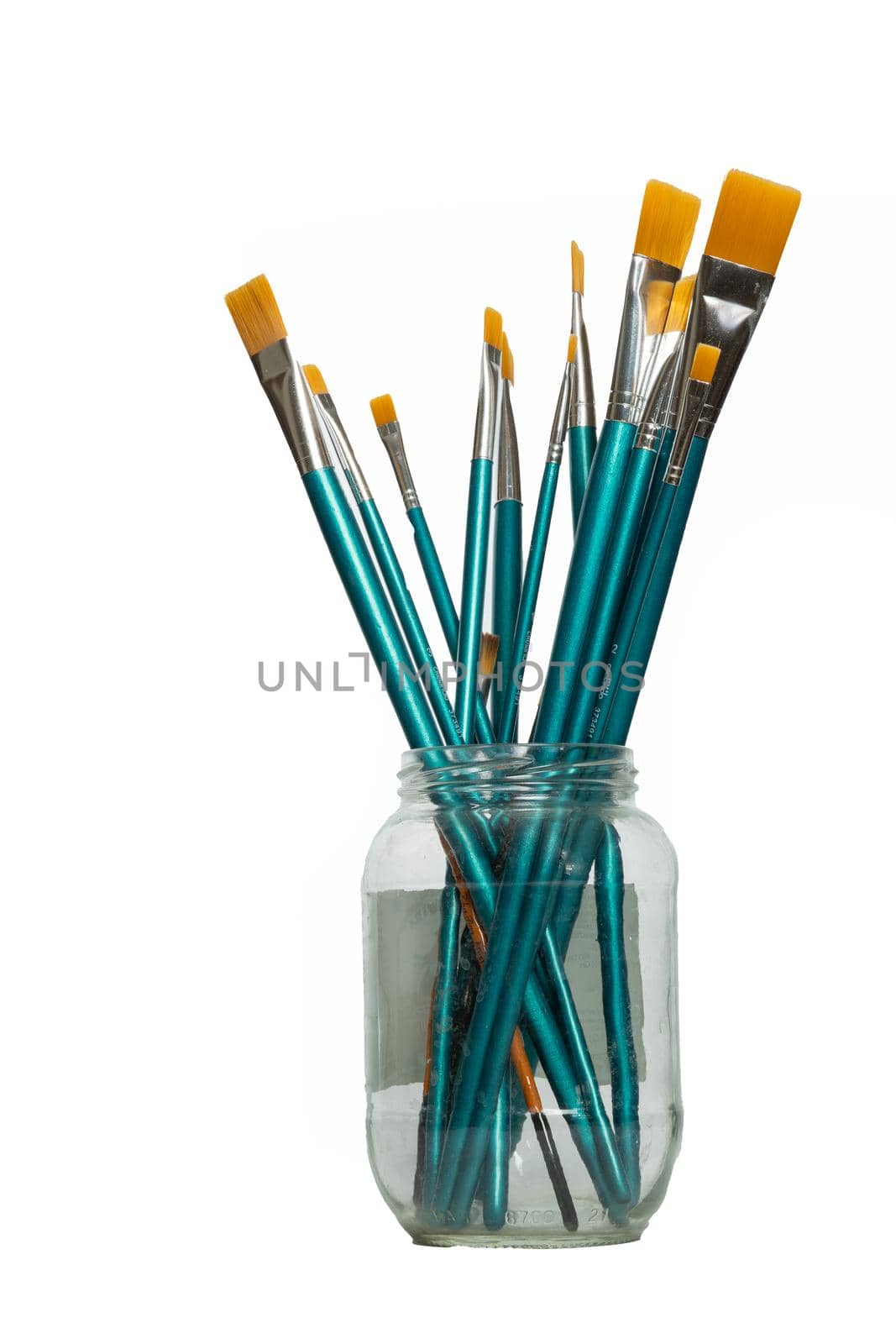 blue brushes in a glass jar white background by joseantona