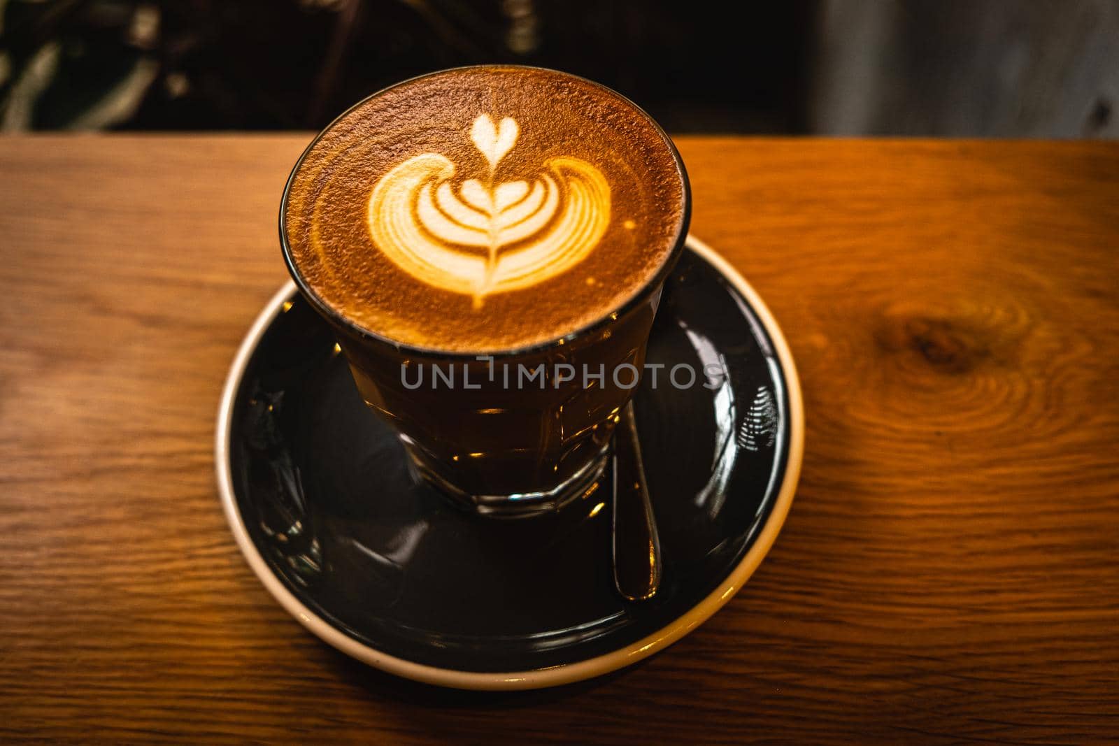 A cup of coffee latte top view with leaf shape foam